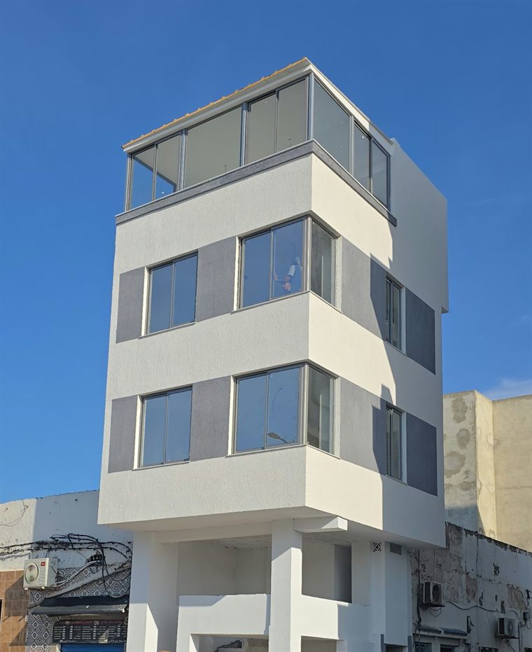 Façade d'immeuble avec menuiserie aluminium et garde-corps à Korba
